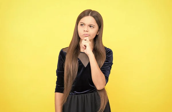 Nachdenkliches Mädchen mit langen Haaren auf gelbem Hintergrund, Entscheidung — Stockfoto