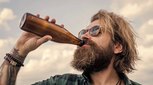 Felfrissülni és ellazulni. érett karizmatikus férfi iszik sört üvegből. Szakállas és bajuszos fickó a szabadban. Üvegből iszom a sört. szakállas férfi vízzel — Stock Fotó