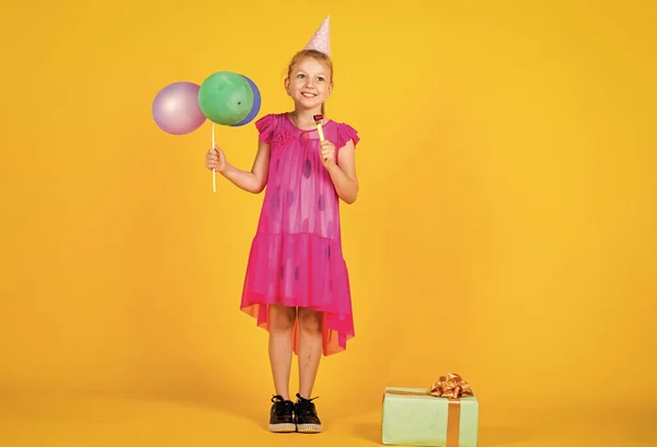 Być w dobrym nastroju. Uśmiechnięte dziecko z balonami. szczęście z dzieciństwa. Ładna nastolatka trzyma pudełko prezentów. Dzieciak świętuje wakacje. Wesoła solenizantka. Najlepsza impreza na świecie. Wszystkiego najlepszego — Zdjęcie stockowe