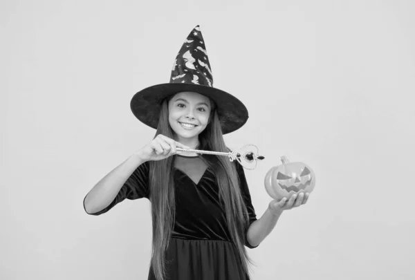 De schrikfabriek. Tienermeisje klaar om het te vieren. Kostuum feestje leuk. Fijne Halloween. Een kind met een heksenhoed. Kind met toverstaf en griezelige pompoen. hekserij en betovering. najaarsvakantie — Stockfoto