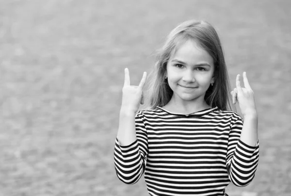 Criança pequena feliz mostrar chifres mão sinais vestindo estilo de moda casual ao ar livre, legal, espaço de cópia — Fotografia de Stock