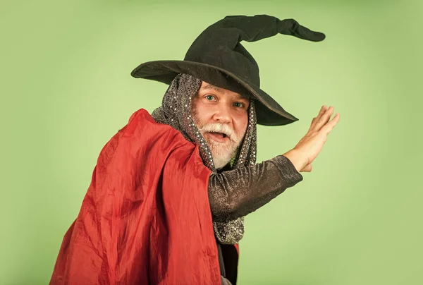 Weird old grandfather with gray beard. Devil man. Holiday and celebration. Magic hat. Best ideas for Halloween. Halloween party. witch man in hat and cloak. happy halloween