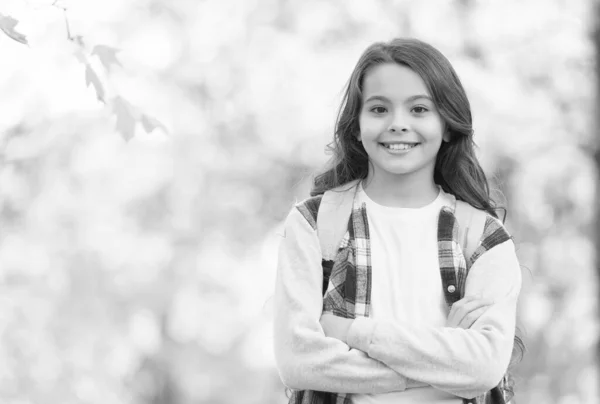 Tonårstjej bär ryggsäck på väg till skolan. barnvandring i höstskogen. faller löv i parken. Säsongsväder. barndoms lycka. skönhet och natur. Glada barn bär avslappnad stil. kopieringsutrymme — Stockfoto