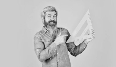 Geometrik şekiller. Matematik ve geometri dersi. Okula dönüyorum. Mühendisliğe hazır. Grafikler için araç. Olgun sakallı adam üçgen cetvel tutuyor. Evde ders çalış. Eğitim. okul öğretmeni üçgen kullan