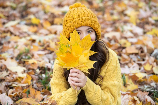 Ritratto di ragazza adolescente in cappello tenere foglia autunno. bambino positivo divertirsi con foglia d'acero giallo — Foto Stock