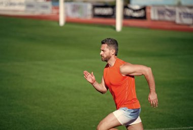 En iyi egzersiz. Başarılı fitness koşucusu. Stadyumdaki koşu pistinde erkek koç. Dayanıklılık ve dayanıklılık. Yarış pistinde koşucu. Meydan okuma ve rekabet. Maraton hızı. Sporcu kazanmak için hızlı koşar.