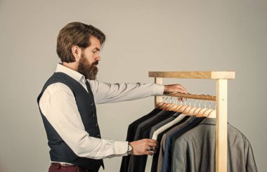 Erkek giyim mağazasında alışveriş yapan hippi, kıyafet konseptini seçiyor.