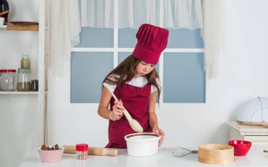 Çocuk mutfakta yemek pişiriyor. Gelecekteki kariyerini seç. Yemek için hazır. Sadece sağlıklı ve organik yiyecekler