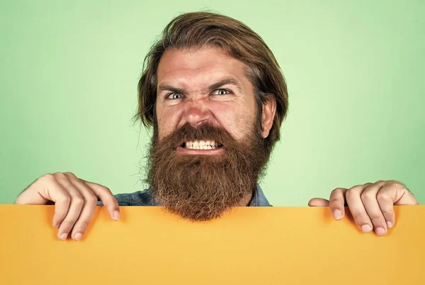 Dentes saudáveis, sorriso bonito. lugar para espaço de cópia. homem barbudo zangado com folha de papel vazia. Serviço de barbearia. conceito de publicidade. Homem brutal com barba e bigode. procurar um emprego — Fotografia de Stock