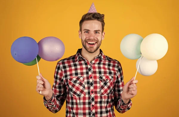 Stilvolle Kerl mit trendiger Frisur tragen kariertes Hemd halten Party-Luftballons, Urlaub — Stockfoto