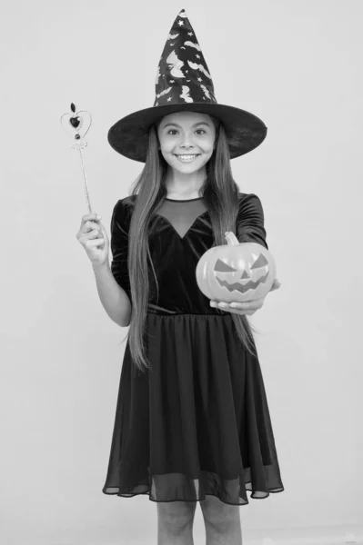 Stregoneria e incantesimo. vacanza autunnale infanzia. teen girl pronto a festeggiare. festa in costume divertente. Buon Halloween. bambino col cappello da strega. bambino tenere bacchetta magica e zucca spettrale. I fantasmi si riuniscono qui — Foto Stock