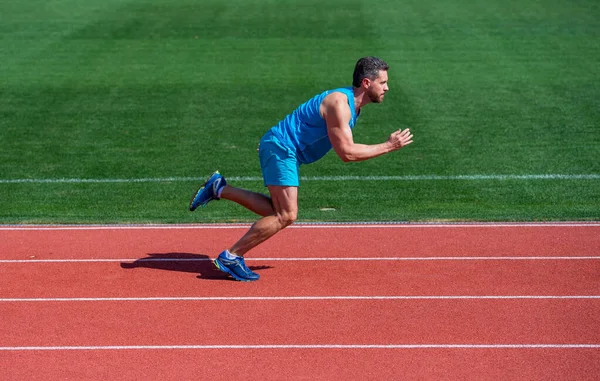 Athletischer muskulöser Mann läuft in Sportbekleidung auf Stadionstrecke, Ziel — Stockfoto