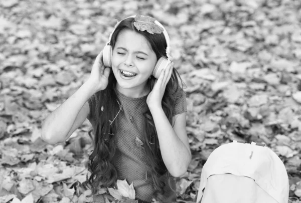 Kindersängerin singt ein Lied, während sie im Freien mit Kopfhörern Musik hört, Herbst — Stockfoto