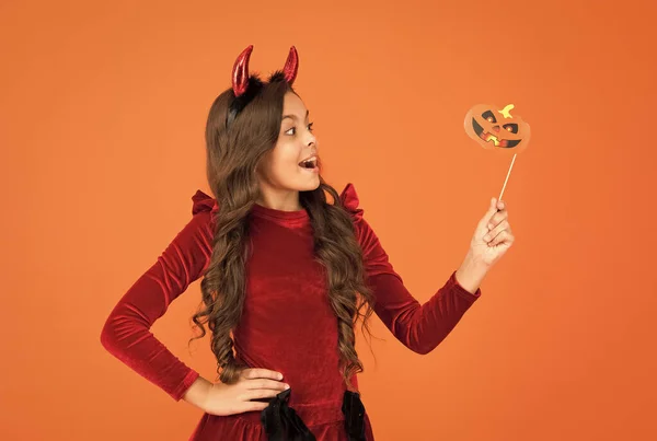 Ik trakteer. tienermeisje heeft lang krullend haar en dragen jurk voor vakantie viering. herfstvakantie. Kindervrije tijd. Fijne Halloween. Een kind draagt duivelshoorns. kind met grappige party attribuut — Stockfoto