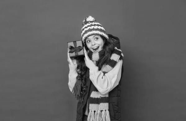 Szczęśliwy nastolatek dziewczyna w dzianiny szalik i kapelusz nosić ciepłe ubrania w sezonie zimowym gospodarstwa prezent pudełko na Boże Narodzenie, zakupy — Zdjęcie stockowe