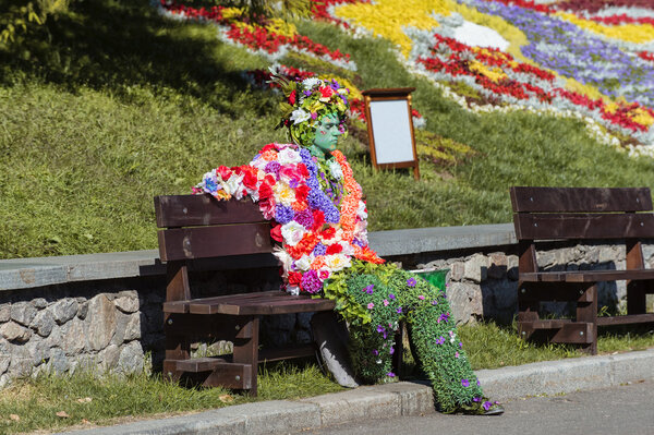 Man in hand made costume from flowers in park