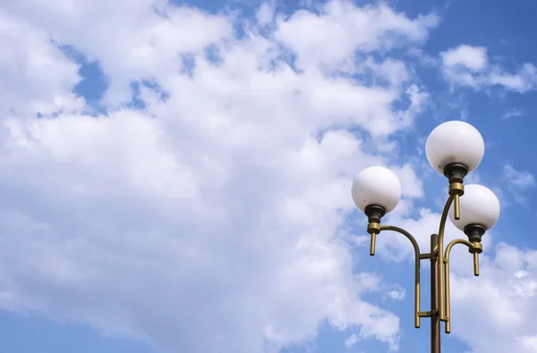 Блакитне небо з хмарами і парковою лампою — стокове фото
