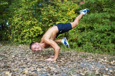 Adam parkta yoga egzersizleri yapıyor.