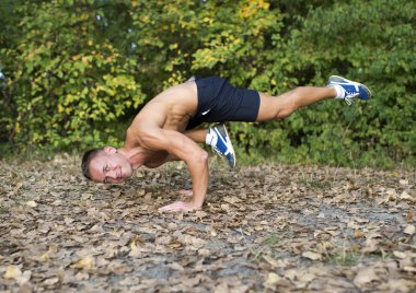 Adam parkta yoga egzersizleri yapıyor.