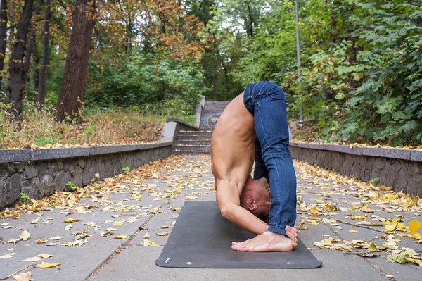 Adam parkta yoga egzersizleri yapıyor. — Stok fotoğraf