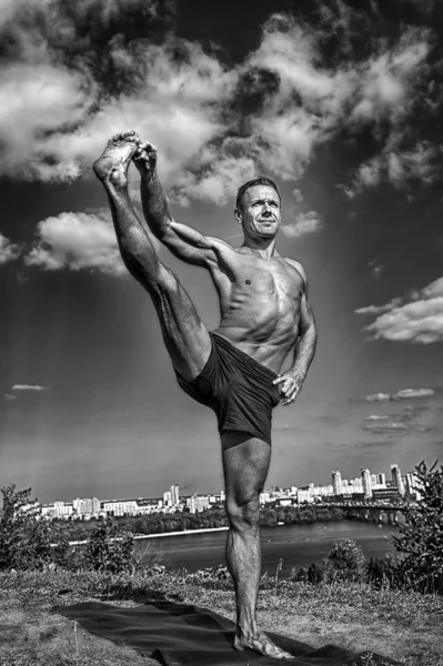 Athletic man doing yoga asanas in the park — Stock Photo, Image