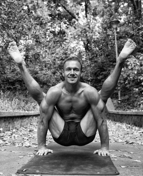 Hombre atlético haciendo asanas de yoga en el parque — Foto de Stock