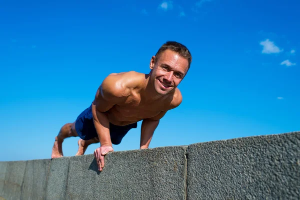 Gelukkig atletische man doen yoga asana's in het park op zonnige dag — Stockfoto