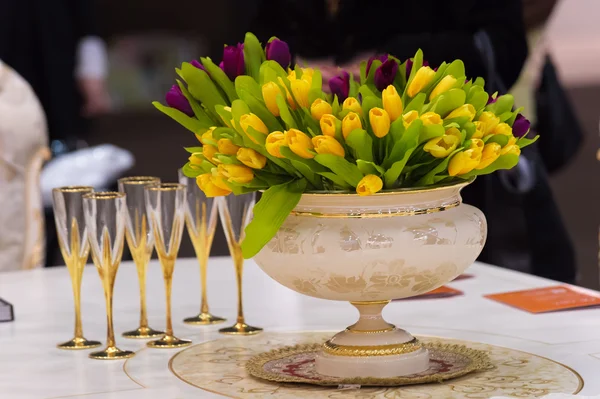 Винтажная ваза с тюльпанами и бокалами шампанского — стоковое фото