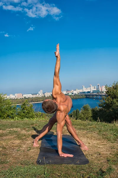 Sportlicher Mann bei Yoga-Asanas im Park an sonnigen Tagen — Stockfoto