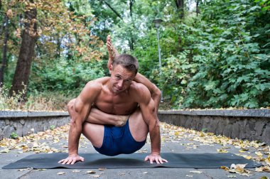 Yoga asanas parkta yapan yakışıklı esnek atletik erkek