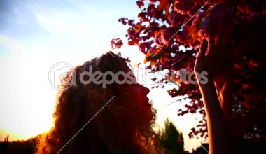 Genç kadın ve gün batımında çiçek açan kiraz