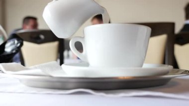 Birisi bardağa süt dökülen