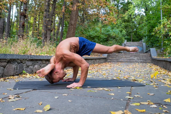 Schöner, flexibler, athletischer Mann macht Yoga-Asanas im Park — Stockfoto