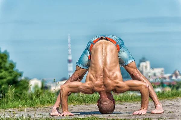 Lekkoatletycznego mężczyzna robi asan jogi w parku w słoneczny dzień — Zdjęcie stockowe