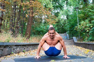 Yoga asanas parkta yapan yakışıklı esnek atletik erkek