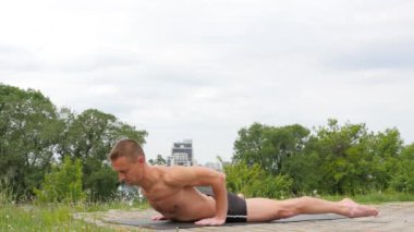 Yoga asanas parkta yapan yakışıklı esnek atletik erkek
