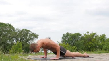 Yoga asanas parkta yapan yakışıklı esnek atletik erkek