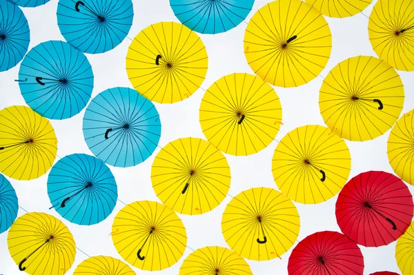 Tło jasne kolorowe parasole żółty, czerwony i niebieski — Zdjęcie stockowe