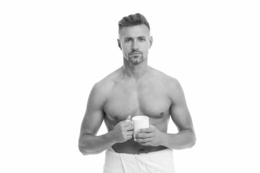 Kaslı gövdeli olgun bir adam evde çay ya da kahve içerken beyaz tenli. Sabah rutini. Gövdesi olan yakışıklı adamın sabah kahvesi..