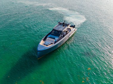 Yaz denizi kıyısında bir tekne turu. Denizdeki lüks yat teknesi. Yaz tatili. Lüks yat manzaralı. Motorlu teknenin panorama hava görüntüsü. Marinaya yüzen bir tekne. Açık deniz.