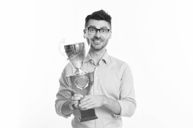 Gözlüklü başarılı bir iş adamı şampiyonluk kupasını tutuyor. İş ödülü ve başarı. İşadamı kazandı. İş başarısı. Başarılı toplantıdaki iş adamı beyazdan izole edilmiş. Müşteri memnuniyeti.