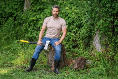 Lumberjack axe. Man with logging axe. Hardworking brutal man. Lumberjack hardworking outdoor. Brutal lumberjack. Brutality and masculinity. Hispanic lumberjack man with axe, advertisement.