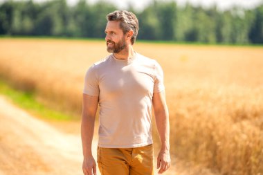 Farmer in field. Hispanic man farmer check agriculture field harvest. Man agronomist farmer. Crop protection. Agriculture farm. Farm man at wheat field. Crop harvest and farming. Man crossing field.