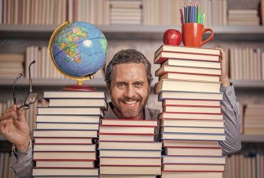 Öğretmenler ve bilgi günü. Zeki öğretmen. Sınıftaki kitap kurdu adam. Kitap edebiyatı öğretmeni. Okul kütüphanesinde eğitim. Adam kitap kurdu bilgi topluyor. Okuma alışkanlıkları.