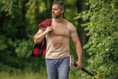 Güçlü terleyen adam ormanda çalışır. Ormanda baltayla keresteci. Oduncu baltayı taşır. Baltalı terli adam. Ormanda baltayla oduncu. Ağır baltalı oduncu..