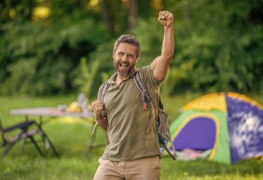 Yaz günü yürüyüş yapan bir adam. Yaz kampı aktivitesi. Yaz kampı. Kamp macerası. Yürüyüş yaşam tarzı. Kamp alanındaki adam. Piknik zamanı. Ormanda çadırlı piknik yapan mutlu bir adam..