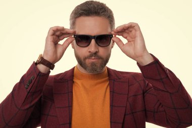 Olgun adam erkek giyim tarzı giyinir. Resmi giysiler. Şık ve modaya uygun. İspanyol manken. Beyaz giysili şık erkek kıyafetleri. İş ceketli ve güneş gözlüklü adam..