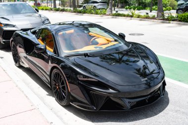 Miami, Florida, ABD - 27 Temmuz 2025: McLaren GT 2022 spor araba. Lüks siyah spor araba McLaren GT. McLaren GT 'nin arabası dışarı park edilmiş, köşe manzaralı..