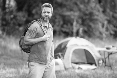 Kamp macerası. Yürüyüş konsepti. Kamp çadırı. Ormanda çadırda çadırda bir adam var. Bir yaz günü doğa yürüyüşçüsü. Yaz kampı ve doğa tatili. Yaz kampındaki adam. Pankart.