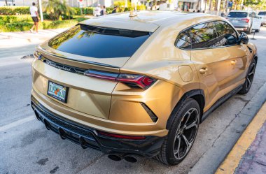 Miami, Florida, USA - April 07, 2025: Car Lamborghini Urus parked outdoor. Golden car, rare view. 2025 Lamborghini Urus hybrid car. Luxury hybrid Lamborghini Urus.